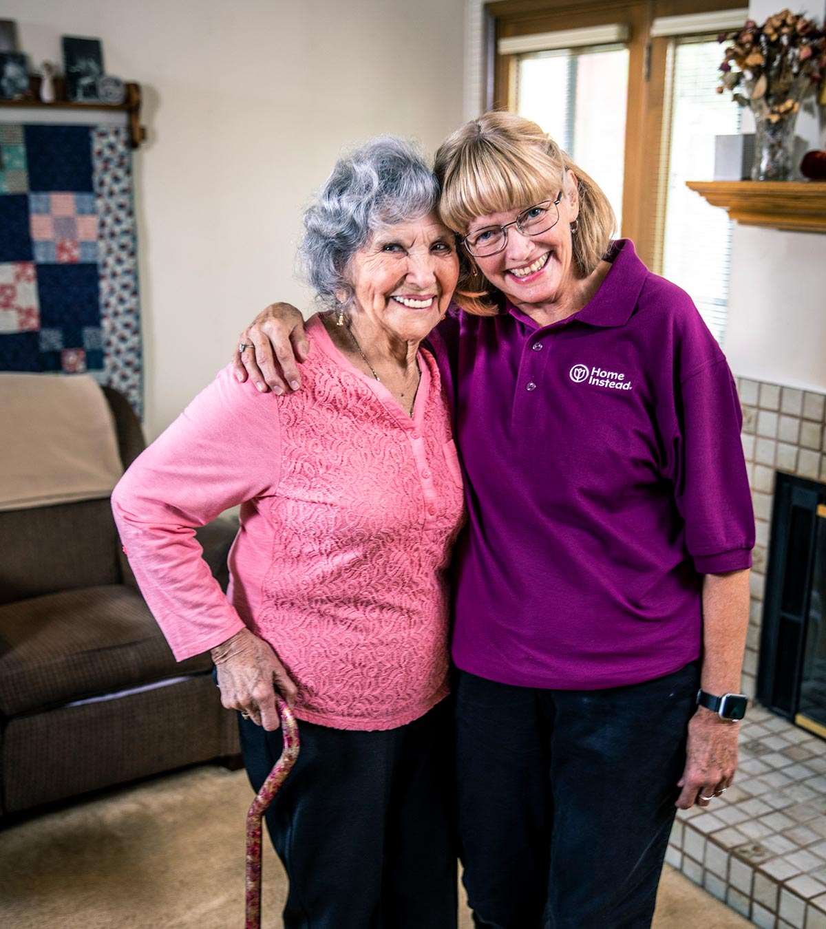 Home Instead CAREGiver and senior standing together smiling