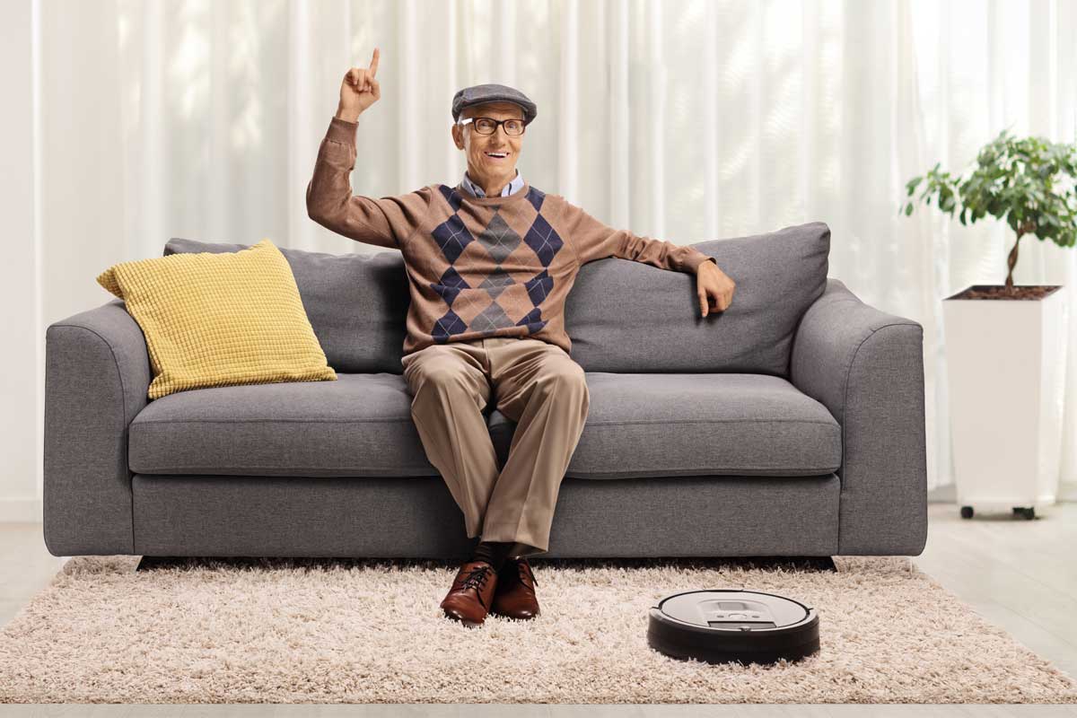 Senior relaxing while the robot vacuums