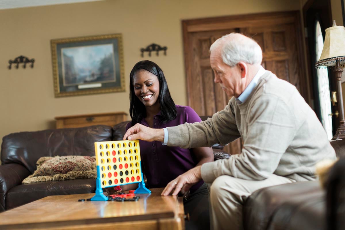 Senior playing a mind challenging agme with a Home Instead PSW