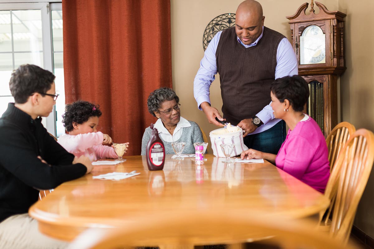 Family an friends having dinner with a senior