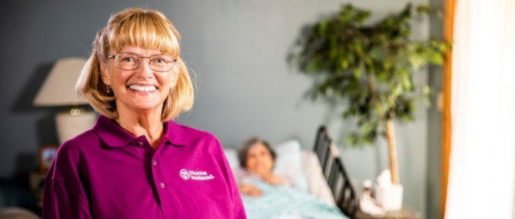 home instead caregiver sitting with a senior in the background